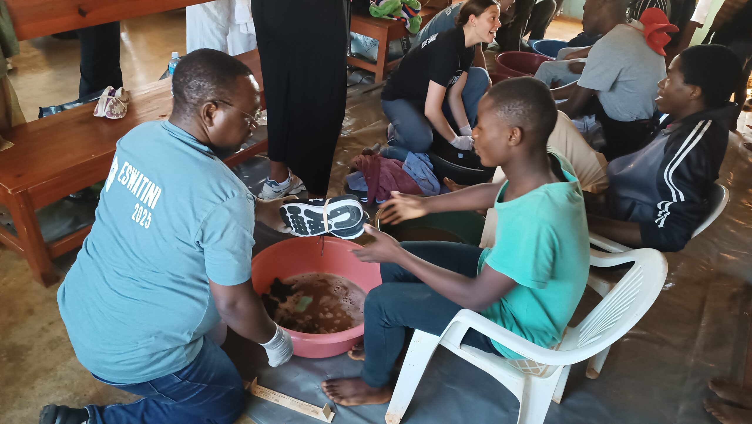 The EHC Africa West Regional Director, Dr. Douglas Mudimba, giving shoes to the needy in Gogololo, Eswatini